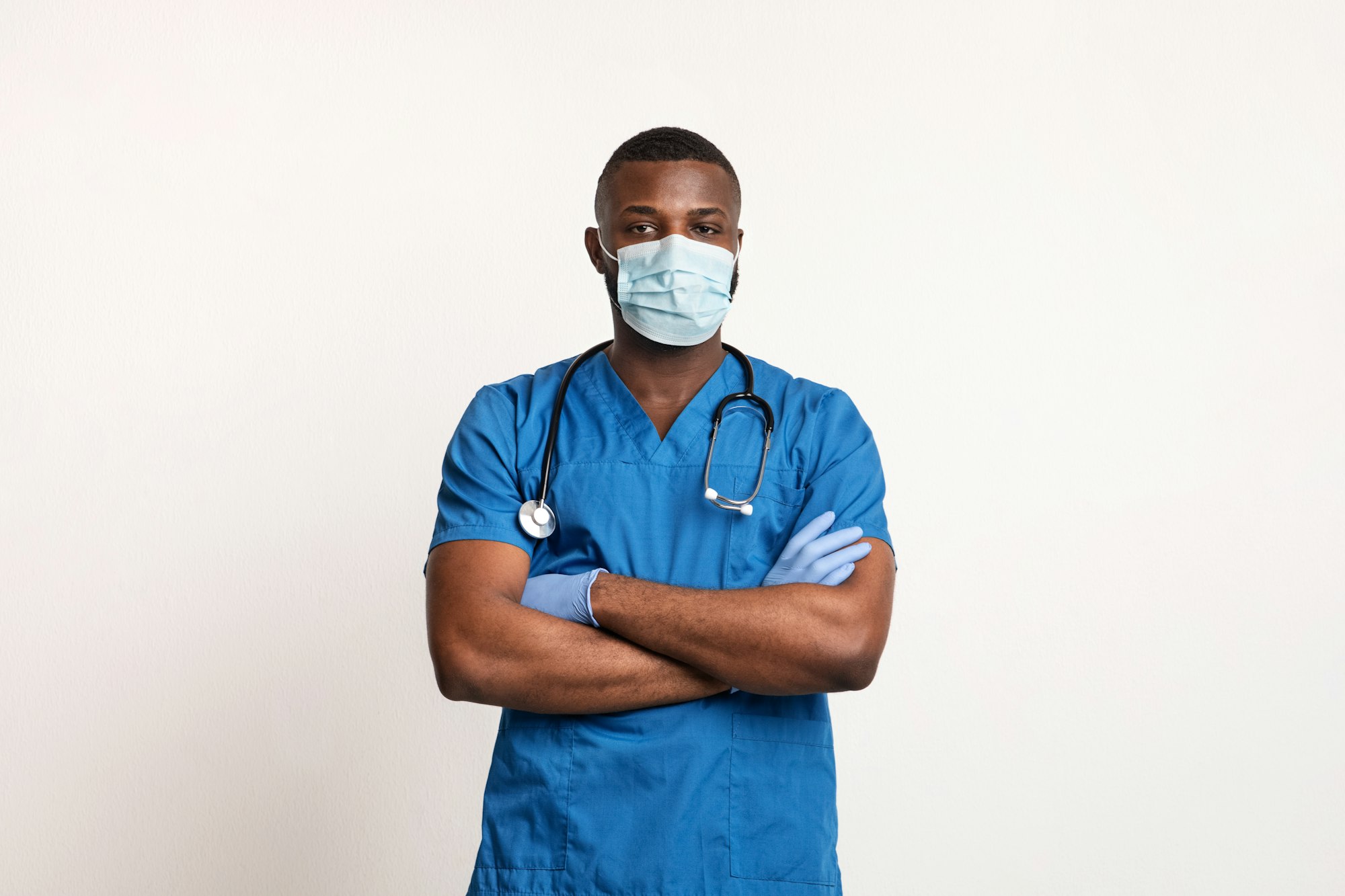 Confident black doctor in face mask and gloves over white